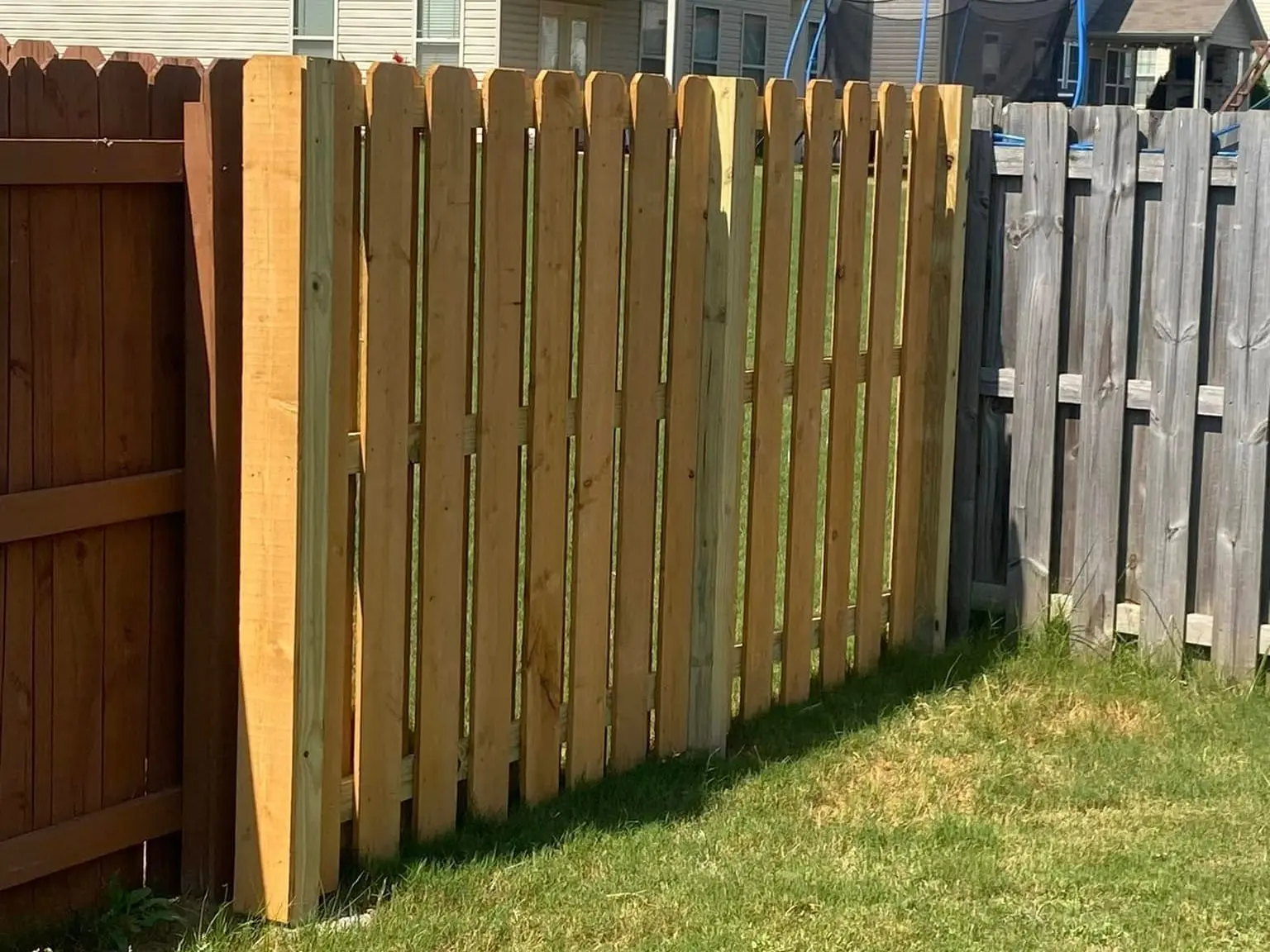Fence repair by Spartan Fence SC, new section beside weathered boards in Spartanburg, SC