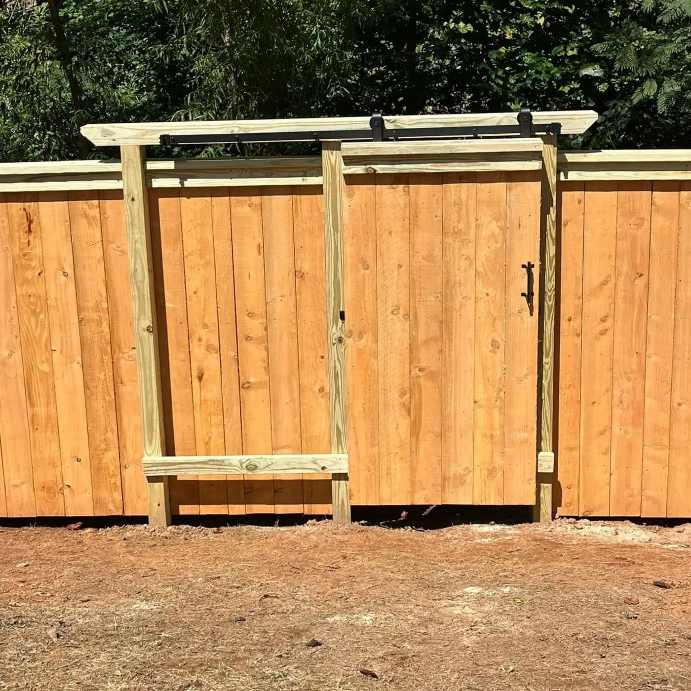 Custom sliding barn-door style gate built into a wood privacy fence by Spartan Fence SC