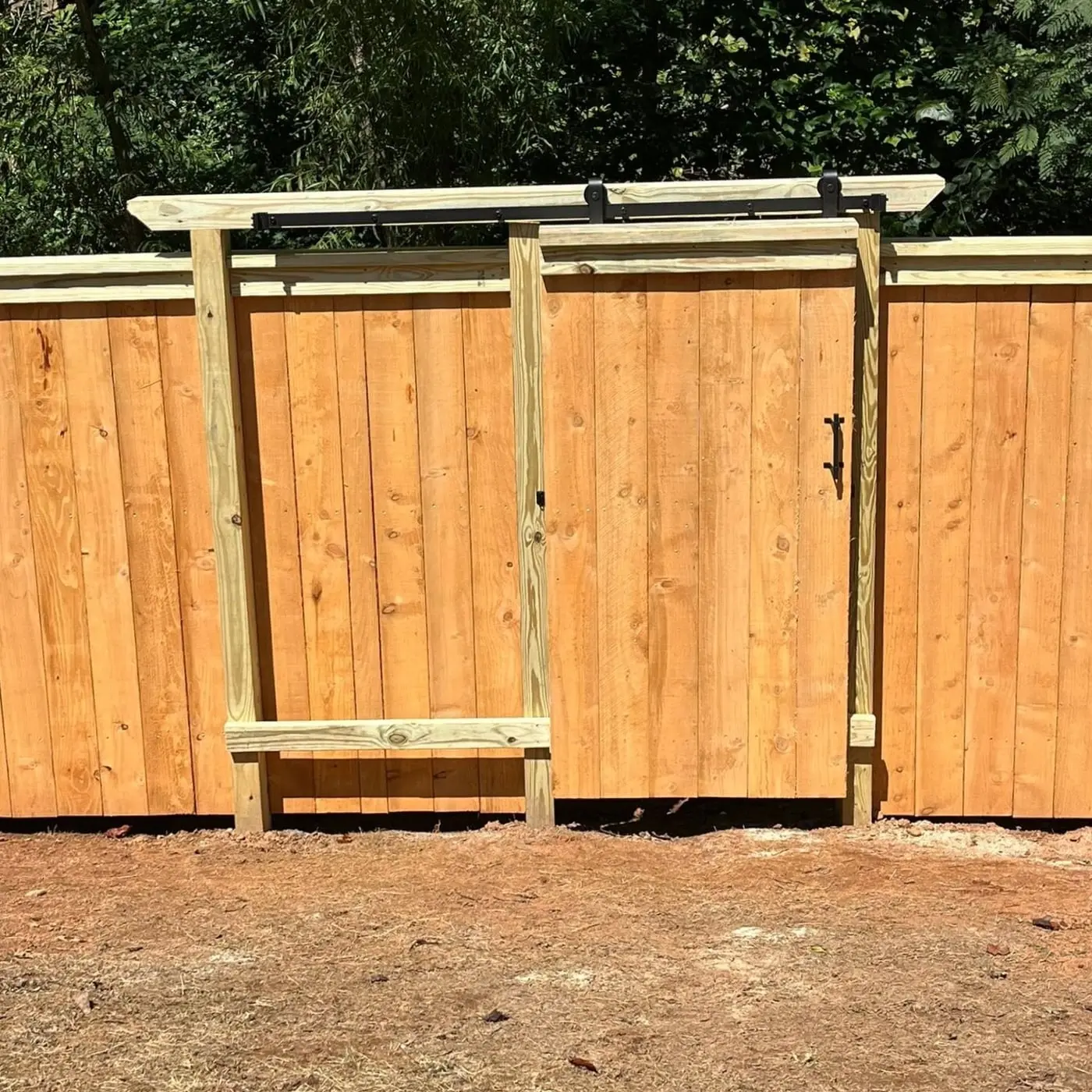 Sliding barn-style gate built into a wood fence by Spartan Fence SC in Woodruff, SC
